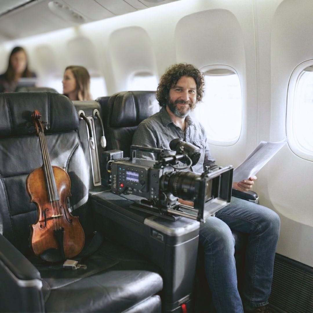 Crew member relaxing in a premium aircraft seat with instruments during a music tour charter flight.